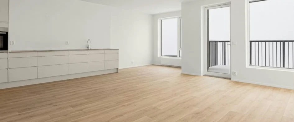 Lichte, lege woonkamer met open keuken, houten vloer en grote ramen
